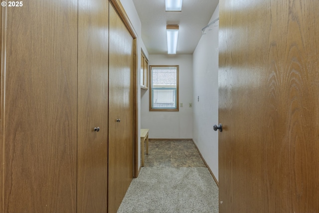 hallway featuring baseboards and carpet flooring