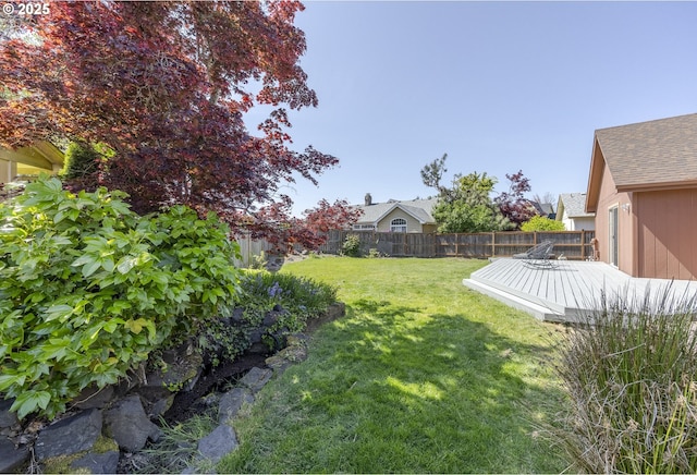 view of yard with a fenced backyard and a wooden deck