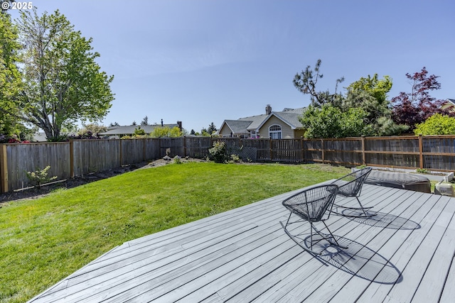 deck with a lawn and a fenced backyard