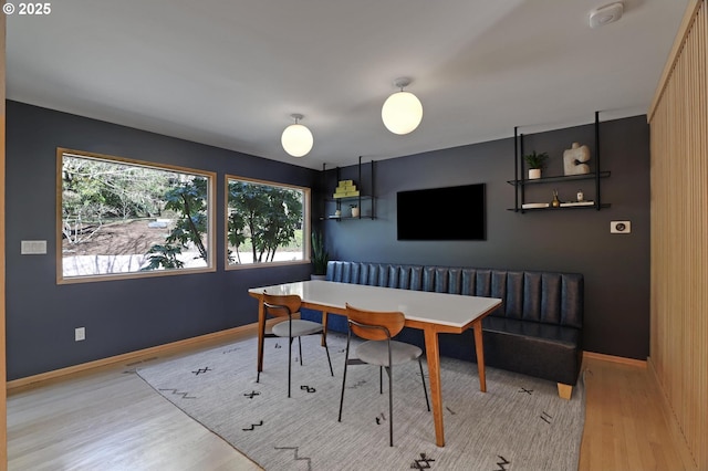 dining area with baseboards, breakfast area, wood finished floors, and a healthy amount of sunlight