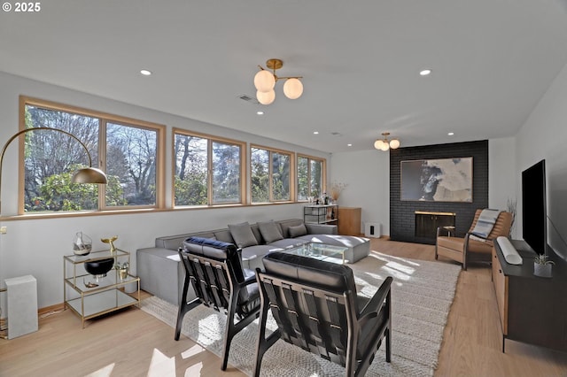 home theater featuring light wood-type flooring, a fireplace, visible vents, and recessed lighting