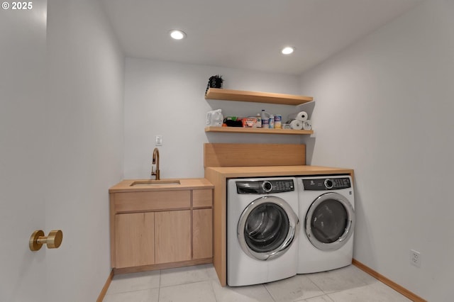 clothes washing area featuring washer and dryer, laundry area, a sink, and recessed lighting