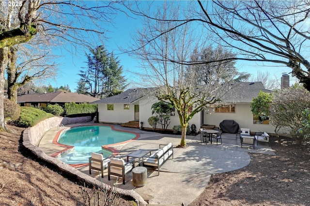 outdoor pool featuring a patio and area for grilling