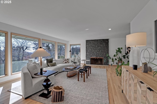 living area with recessed lighting, a fireplace, and light wood finished floors