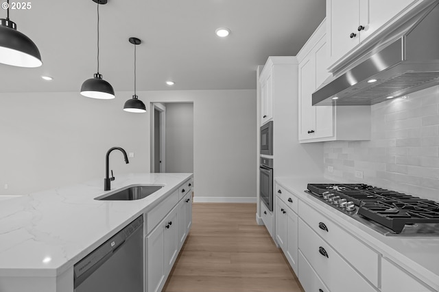 kitchen featuring extractor fan, pendant lighting, sink, white cabinets, and stainless steel appliances