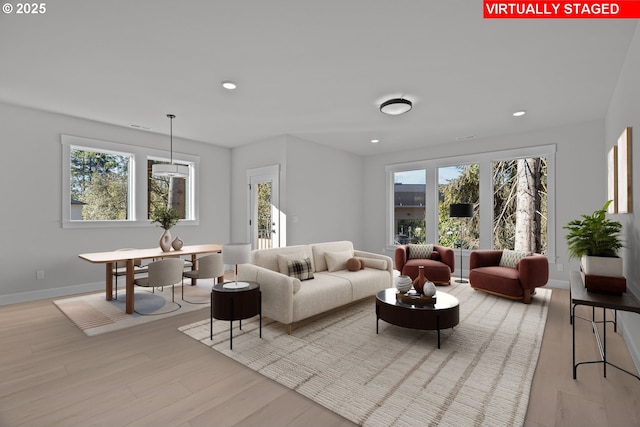 living room with a wealth of natural light and light hardwood / wood-style flooring