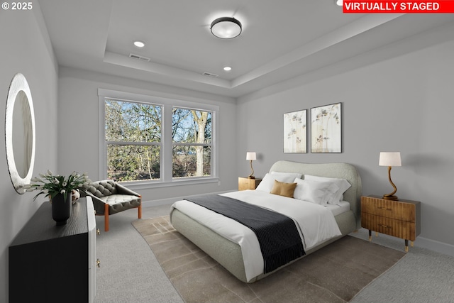 bedroom featuring a raised ceiling and carpet floors