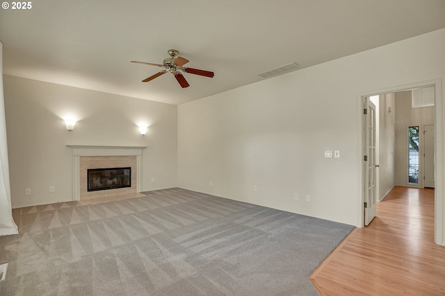 4698 Black Forest Ct, Lake Oswego, OR 97035 - unfurnished living room featuring a ceiling fan, a tiled fireplace, and wood finished floors