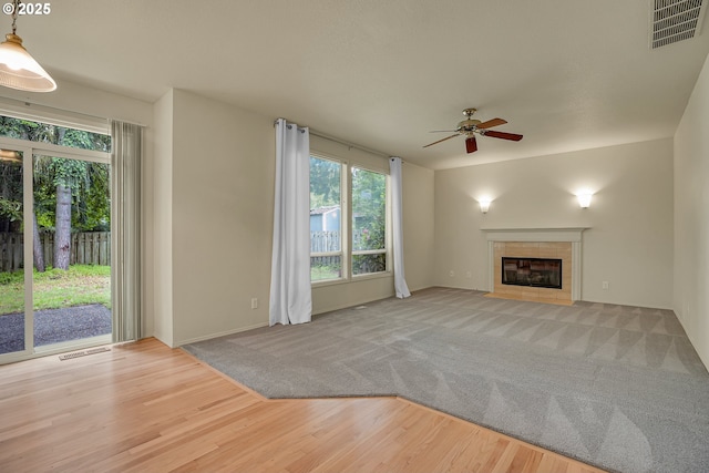 4698 Black Forest Ct, Lake Oswego, OR 97035 - unfurnished living room featuring ceiling fan, a tiled fireplace, wood finished floors, and baseboards