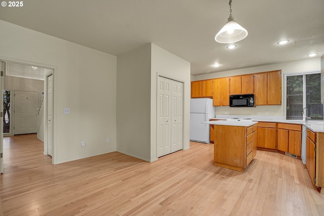 4698 Black Forest Ct, Lake Oswego, OR 97035 - kitchen with black microwave, freestanding refrigerator, light wood-style floors, light countertops, and a center island