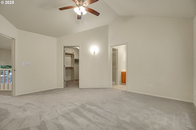 4698 Black Forest Ct, Lake Oswego, OR 97035 - unfurnished bedroom featuring a walk in closet, light carpet, vaulted ceiling, and baseboards