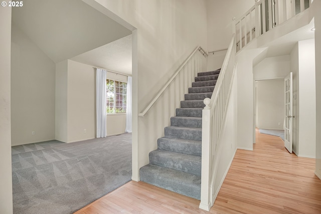 4698 Black Forest Ct, Lake Oswego, OR 97035 - stairs featuring wood finished floors, a towering ceiling, and baseboards