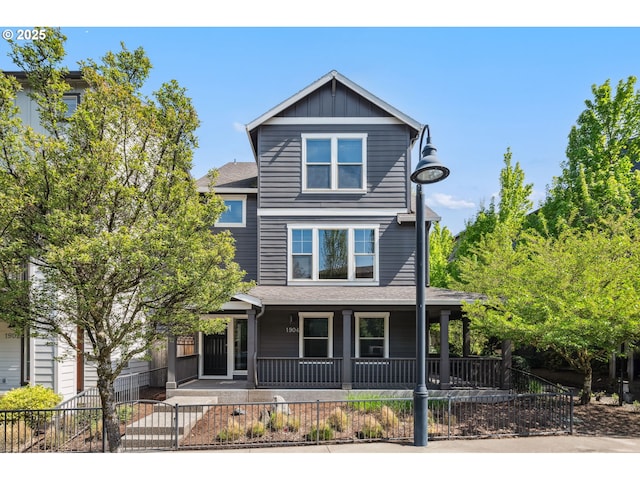 view of front of house featuring board and batten siding, a fenced front yard, and a porch