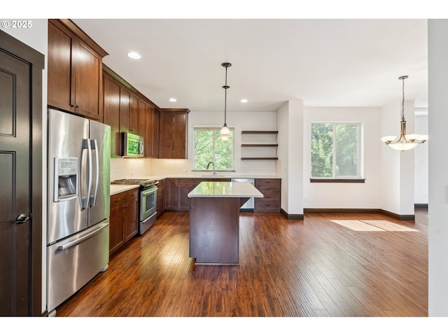 kitchen featuring dark wood finished floors, appliances with stainless steel finishes, a wealth of natural light, and tasteful backsplash