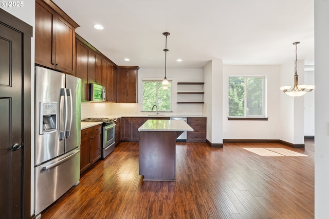1904 SW 144th Ave, Beaverton, OR 97005 - kitchen featuring dark wood finished floors, appliances with stainless steel finishes, a wealth of natural light, and tasteful backsplash