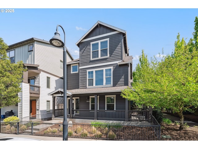 view of front of house featuring board and batten siding, a porch, and a fenced front yard