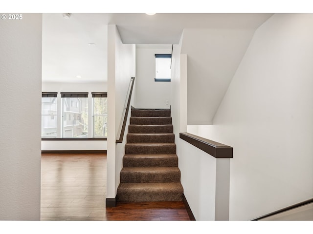 stairway featuring plenty of natural light, recessed lighting, and wood finished floors