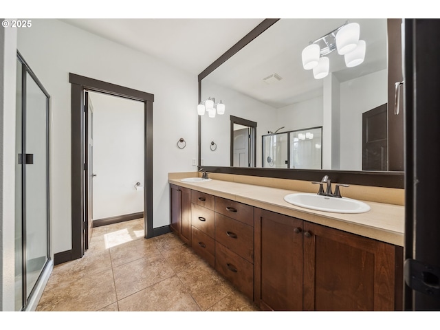 full bath featuring double vanity, baseboards, a sink, and a stall shower