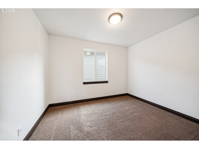 unfurnished room with baseboards and carpet flooring