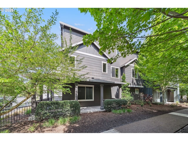 view of front of house featuring covered porch, fence, and board and batten siding