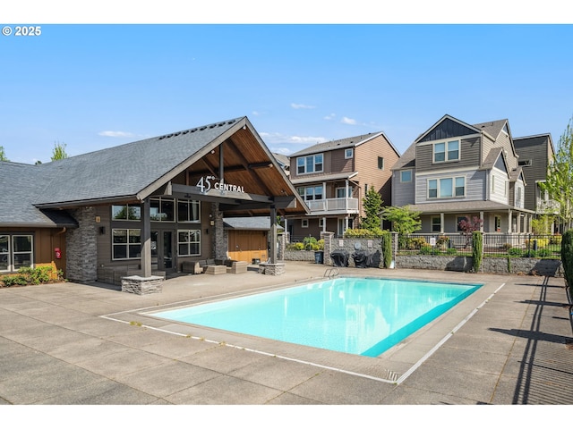 view of pool with a fenced in pool, fence, a patio, and a residential view