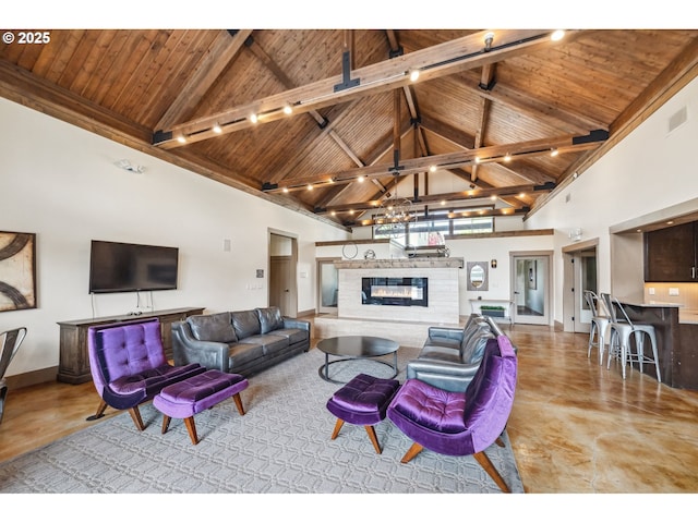 living area featuring high vaulted ceiling, a glass covered fireplace, beamed ceiling, visible vents, and wood ceiling