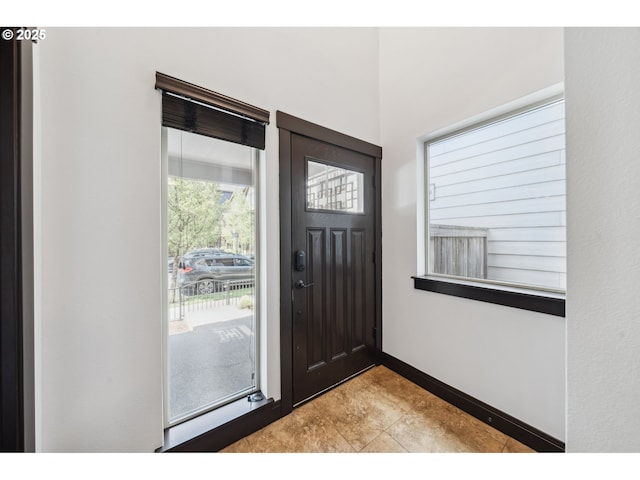 foyer entrance with baseboards and tile patterned flooring