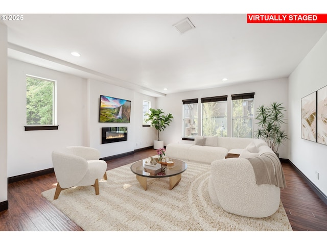 living room featuring a glass covered fireplace, plenty of natural light, and recessed lighting