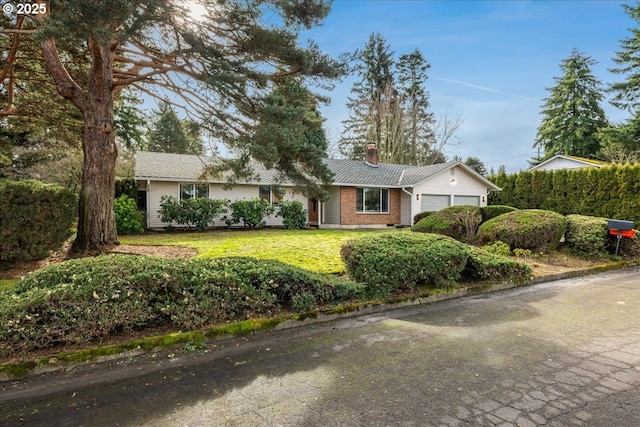 ranch-style home with a garage and a front lawn