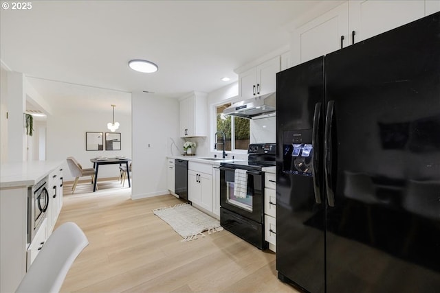 kitchen featuring sink, light hardwood / wood-style flooring, white cabinets, and black appliances