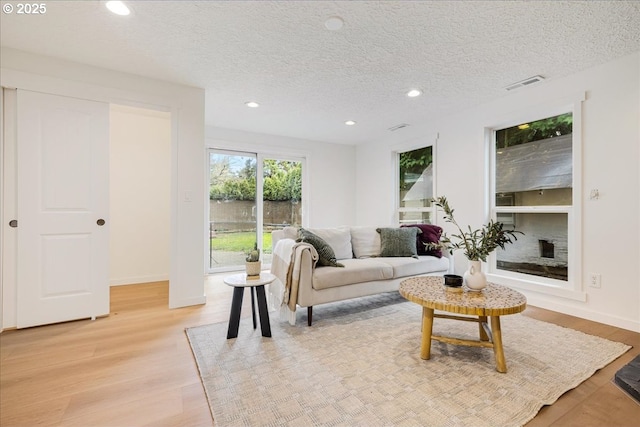 living room featuring light hardwood / wood-style flooring and a textured ceiling