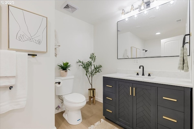 bathroom with vanity, wood-type flooring, and toilet