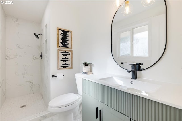 bathroom featuring tiled shower, vanity, and toilet