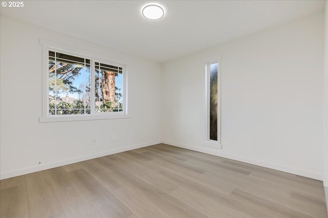 spare room featuring plenty of natural light and light hardwood / wood-style flooring