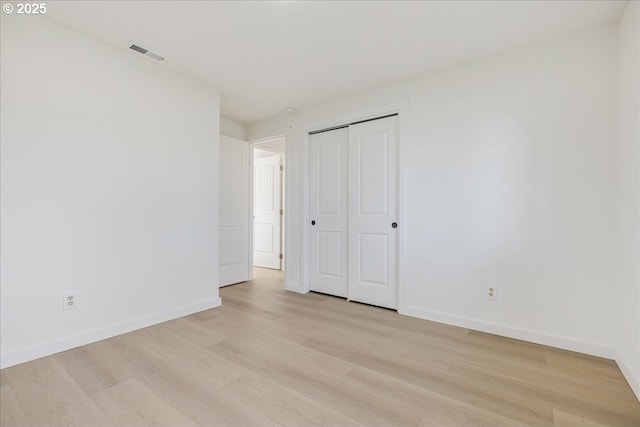 unfurnished bedroom with light hardwood / wood-style floors and a closet