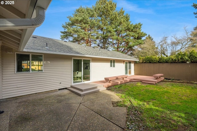 back of property with a patio, a wooden deck, and a lawn