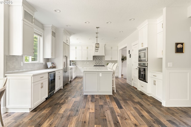 1314 NW Abernethy Rd, Portland, OR 97229 - kitchen with stainless steel appliances, beverage cooler, white cabinetry, and recessed lighting
