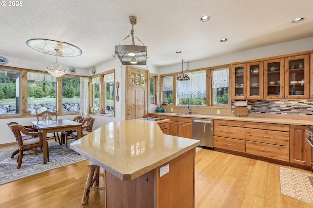 52135 E Terra Fern Dr, Sandy, OR 97055 - kitchen featuring dishwasher, light wood-style flooring, glass insert cabinets, pendant lighting, and recessed lighting