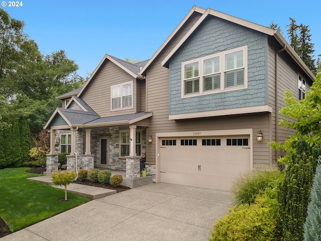 craftsman-style home featuring a porch, a garage, and a front yard