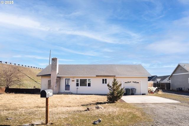 single story home with an attached garage, a chimney, fence, and concrete driveway