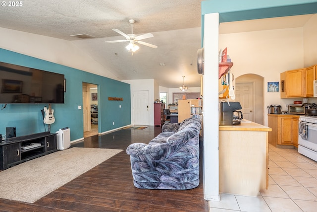 1280 Peets Ct, Eugene, OR 97402 - living area with ceiling fan, lofted ceiling, light wood-style floors, arched walkways, and a textured ceiling