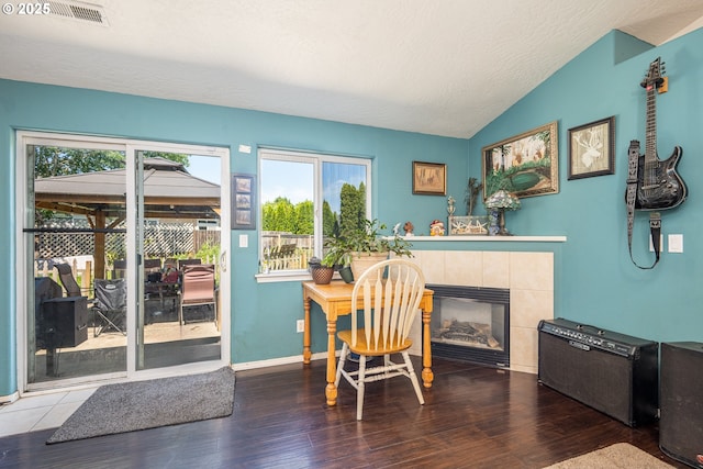 1280 Peets Ct, Eugene, OR 97402 - dining room featuring plenty of natural light, vaulted ceiling, a tile fireplace, and wood finished floors