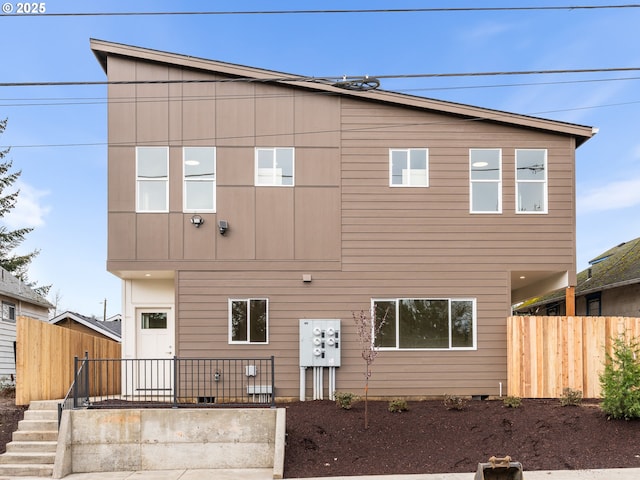 rear view of house featuring fence