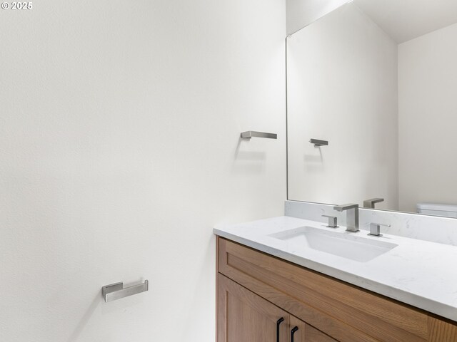 half bathroom with vanity and toilet