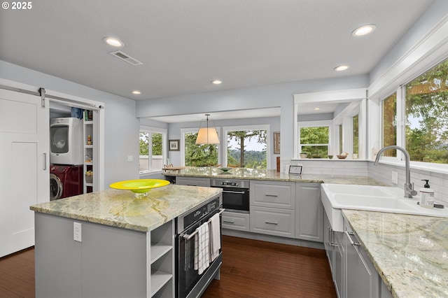 48 Eagle Crest Dr Unit 4A, Lake Oswego, OR 97035 - kitchen with stacked washer / dryer, oven, a sink, plenty of natural light, and recessed lighting