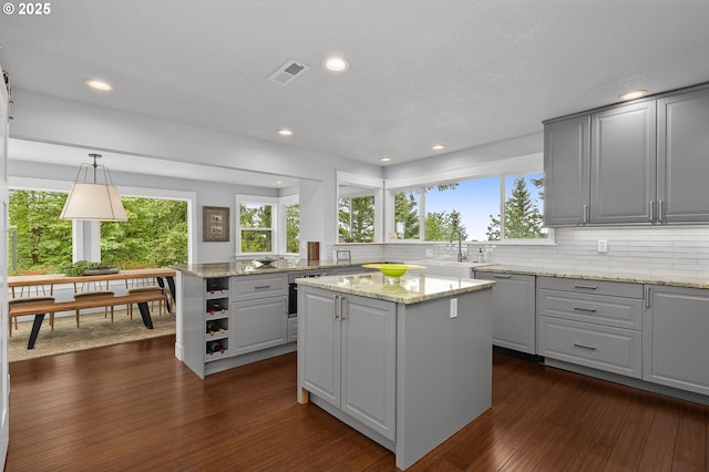 48 Eagle Crest Dr Unit 4A, Lake Oswego, OR 97035 - kitchen with a kitchen island, backsplash, dark wood finished floors, recessed lighting, and light stone countertops