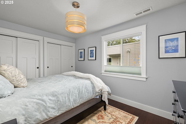 48 Eagle Crest Dr Unit 4A, Lake Oswego, OR 97035 - bedroom with two closets, baseboards, and dark wood-style floors