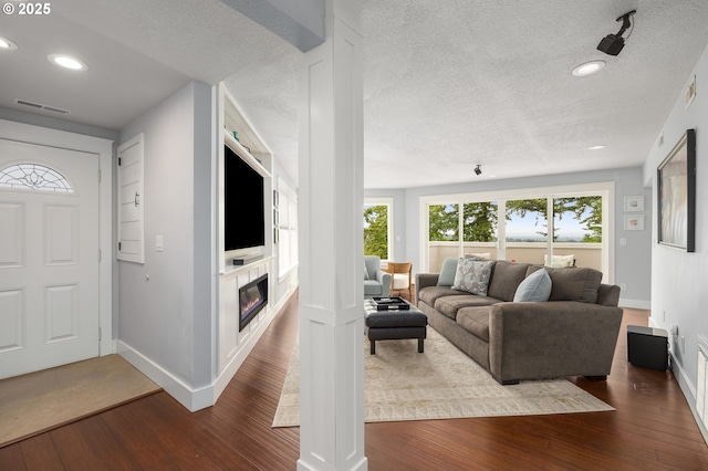 48 Eagle Crest Dr Unit 4A, Lake Oswego, OR 97035 - living room with dark wood-type flooring, a textured ceiling, baseboards, recessed lighting, and a glass covered fireplace