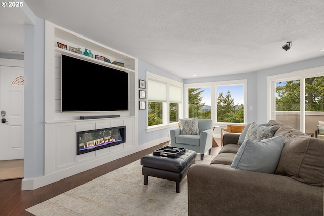 48 Eagle Crest Dr Unit 4A, Lake Oswego, OR 97035 - living area featuring a glass covered fireplace, wood finished floors, a textured ceiling, and baseboards