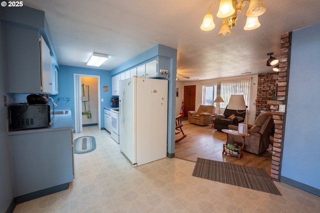 1630 SW Riverhill Dr, Hermiston, OR 97838 - kitchen featuring white appliances, a chandelier, light flooring, blue cabinetry, and open floor plan